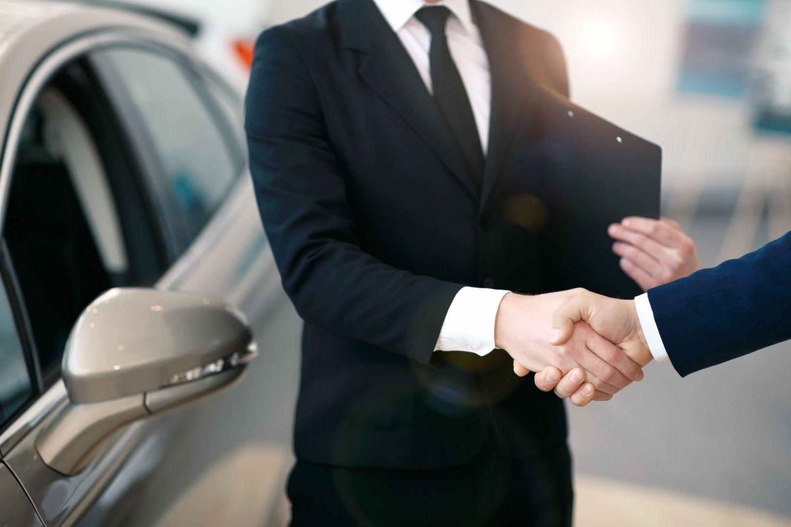 Handschlag von zwei Männern vor einem Auto